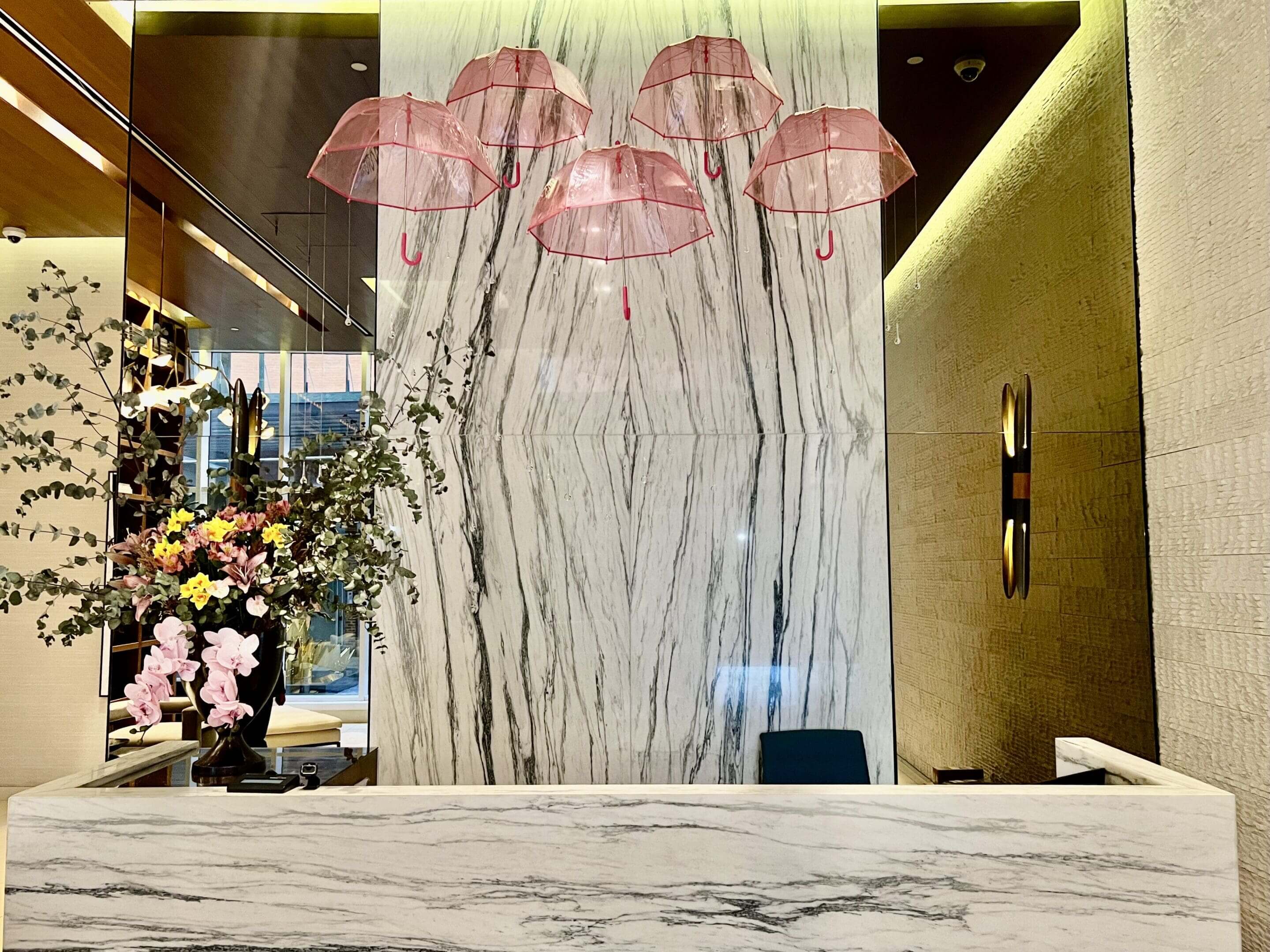 Pink umbrellas above marble reception desk.